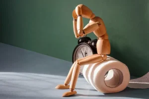 wooden man sitting on toilet paper roll